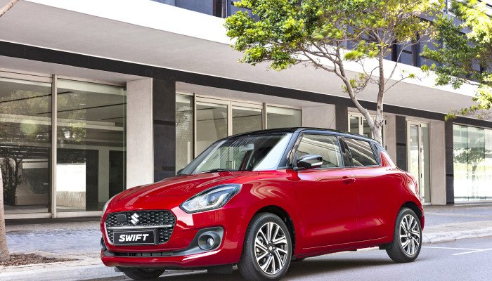 Mẫu xe Suzuki Swift màu xanh dương nhỏ gọn đậu trên phố, minh họa cho dòng xe đô thị tiết kiệm nhiên liệu của Suzuki