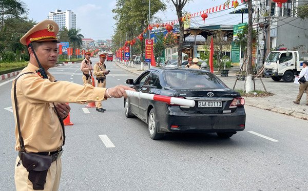 Cảnh sát giao thông đang dừng một người đi xe máy để kiểm tra tại điểm kiểm tra giao thông, đảm bảo tuân thủ luật.