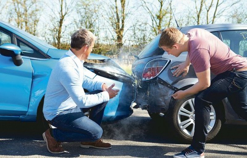Cảnh sát giao thông đang xử lý hiện trường tai nạn, người điều khiển xe đứng cạnh xe bị hư hỏng