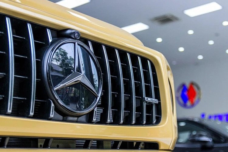 Chi tiết lưới tản nhiệt và logo đen trên Mercedes G63 vàng cát
