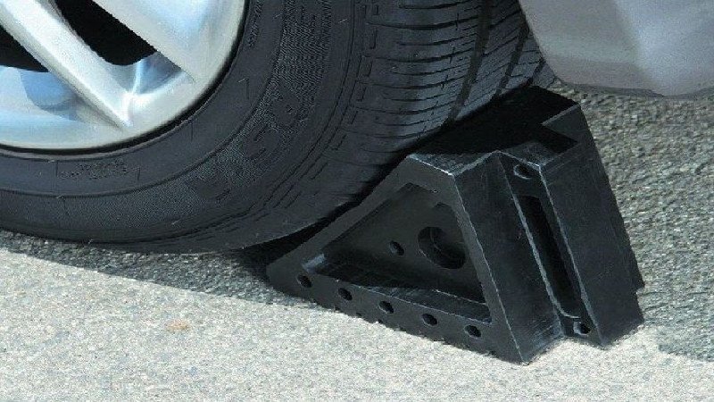Dùng vật chặn bánh xe đảm bảo an toàn khi thay lốp xe ô tô dự phòng