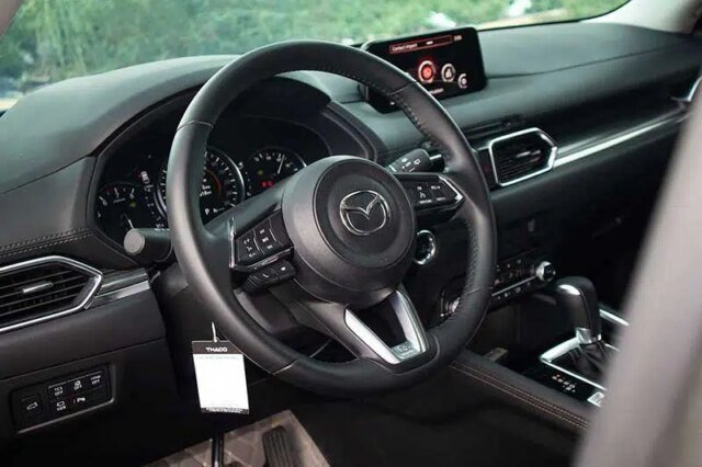 Khoang lái Mazda CX-5 2023 với vô lăng bọc da và màn hình hiển thị