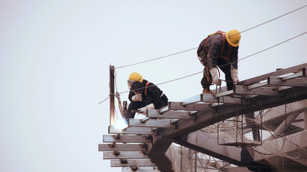 Người công nhân với mũ bảo hộ, tượng trưng cho sự chuẩn bị và ý thức an toàn khi đối mặt rủi ro