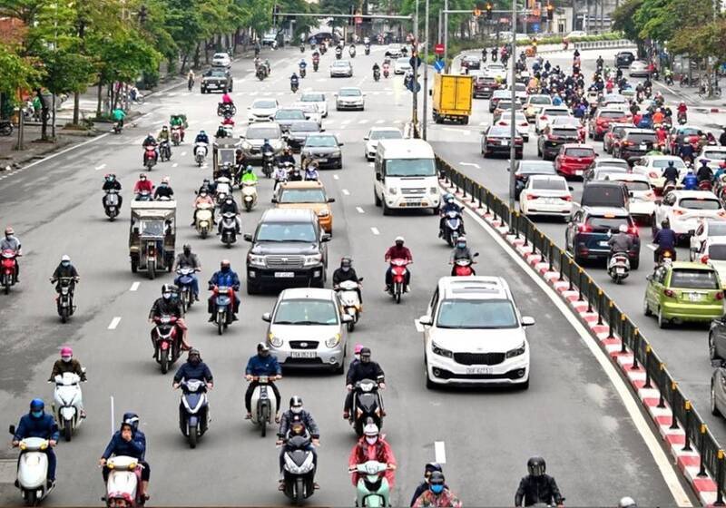Người điều khiển xe máy vượt ẩu trên đường phố đông đúc, tiềm ẩn nguy hiểm và vi phạm lỗi vượt xe không đúng quy định.