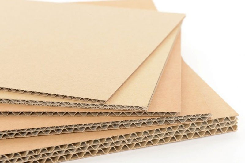 Người dùng đang tỉ mỉ bao bọc xe máy bằng bìa carton để vận chuyển an toàn