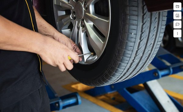 Người lái xe đang kiểm tra áp suất lốp để xác định nguyên nhân lốp xẹp