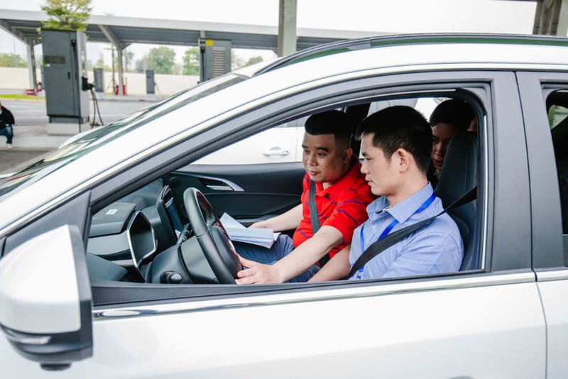 Người quản lý đánh giá hồ sơ, tượng trưng cho quá trình phát triển kỹ năng lái xe chuyên nghiệp.