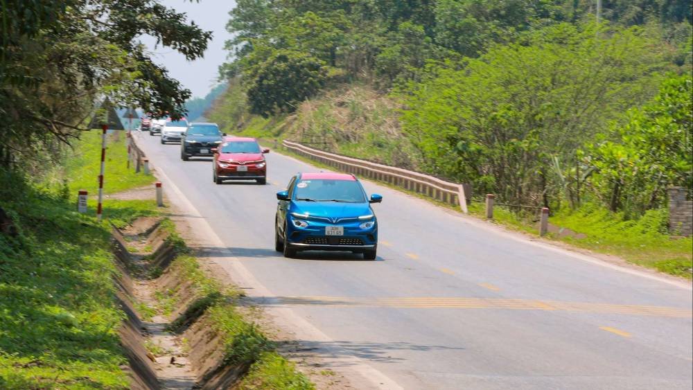 Ô tô điện đang di chuyển trên đường đèo dốc với khung cảnh núi rừng bao quanh