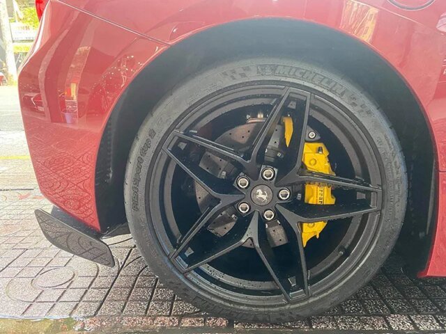Thân xe Ferrari 488 Pista Spider màu đỏ mận với vành đen và cùm phanh vàng.
