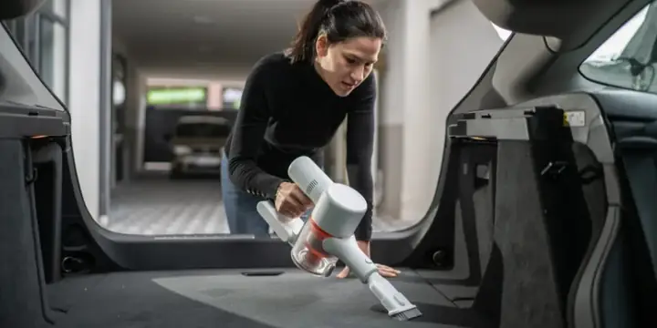 Phụ Nữ Đang Sử Dụng Máy Hút Bụi Mini Làm Sạch Cốp Xe Ô Tô